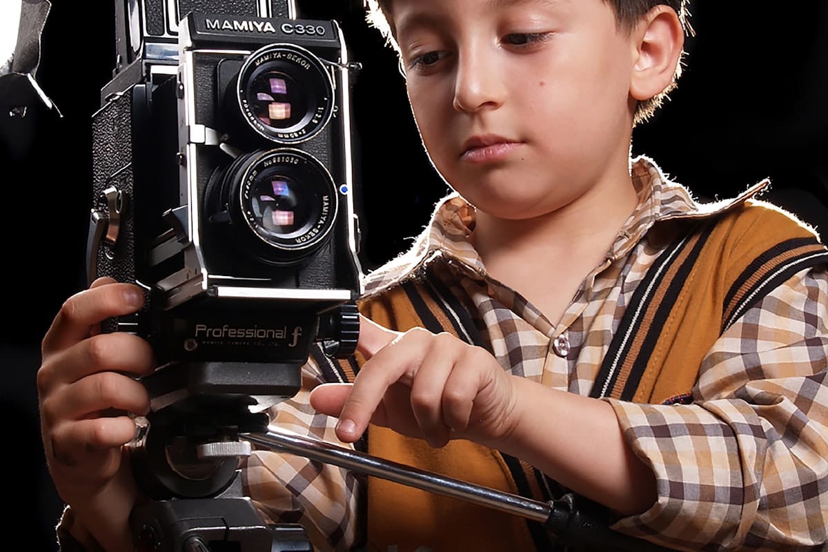 Enfant tenant un appareil photo entre ses mains